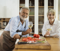 couple holding wine glasses smiling in kitchen